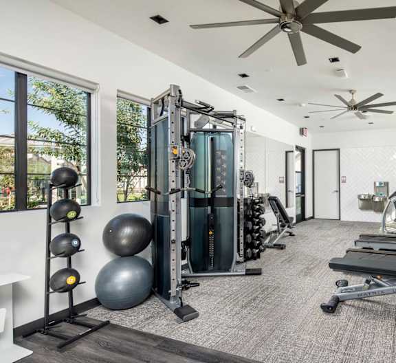 A spacious home gym with a variety of equipment including a treadmill, weights, and a bench press. at Grandstone at Sunrise, Peoria, AZ, 85383