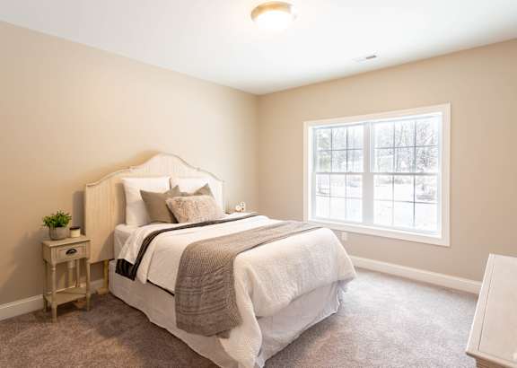 A bedroom with a large bed and a window.