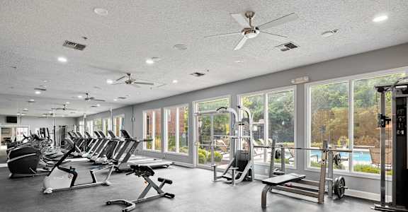 A gym with a variety of equipment including treadmills, weights, and exercise machines.