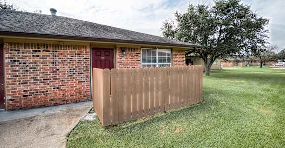 A house with a red door and a brown fence.