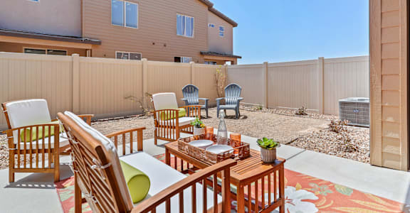 a patio with a table and chairs and a privacy fence