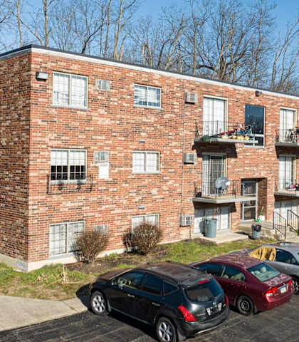 A parking lot with cars in front of a brick building.