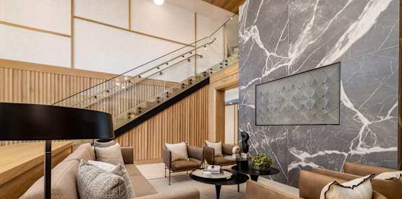 A living room with a brown couch and a black floor lamp.