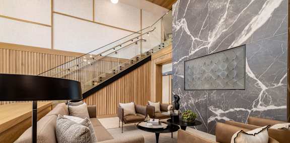 A living room with a brown couch and a black floor lamp.