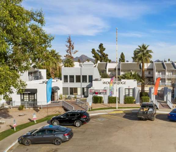 A parking lot with cars and a building in the background.