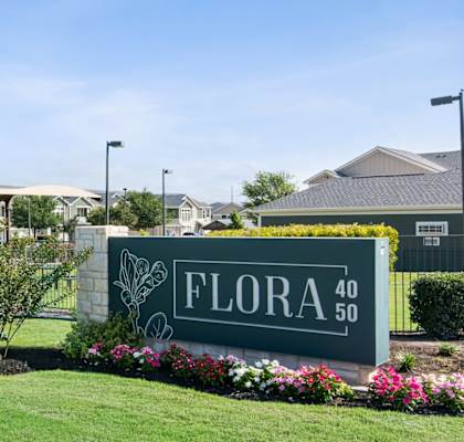 A sign that says "FLORA 40" is in front of a building.