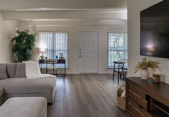 Living room with sectional sofa and patio door in a 653-square-foot one-bedroom apartment