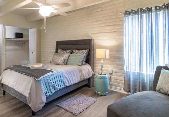 Bedroom with seating area and soft natural light in a 653-square-foot apartment home