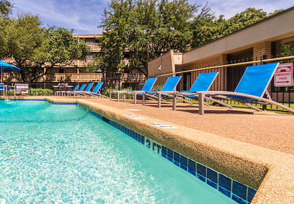 Wide view of the swimming pool and pool deck seating at Harvard Square Apartments