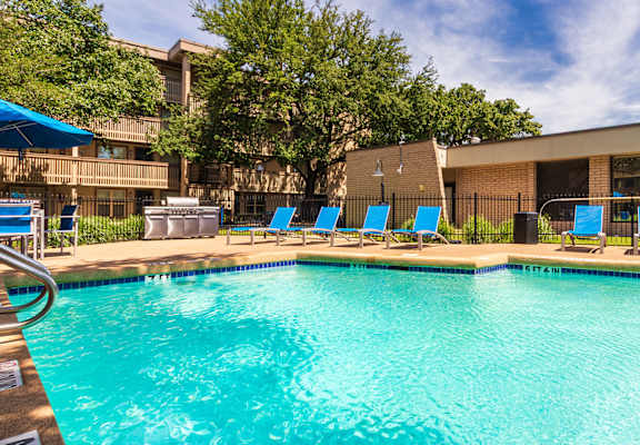 Swimming pool with surrounding sundeck and apartment buildings at Harvard Square Apartments