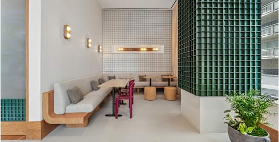 A modern living room with a long couch and a green wall.