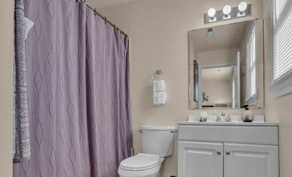 a bathroom with a shower and a toilet and a sink