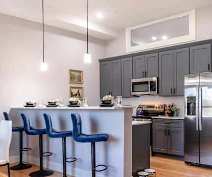 A kitchen with a bar area and a dining table.