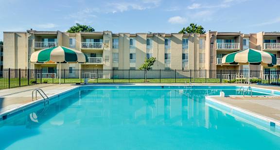 A swimming pool in front of apartment buildings.