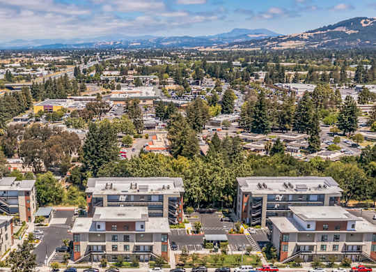 A bird's eye view of a town with buildings, cars, and trees.