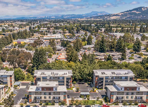 A bird's eye view of a town with buildings, cars, and trees.