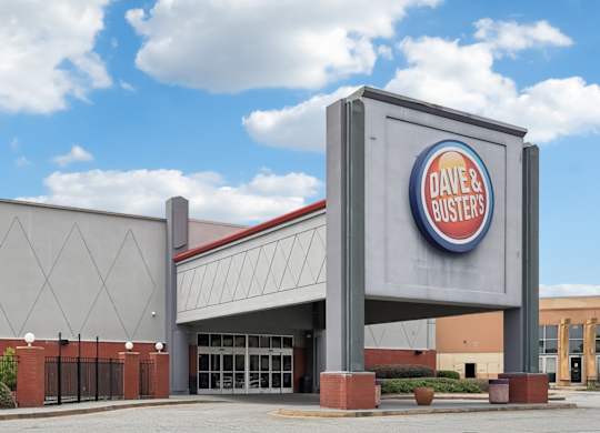 Dave and Buster's storefront with a blue sky and clouds in the background.