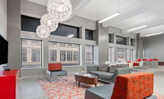 A modern living room with a red cabinet and a grey sofa.