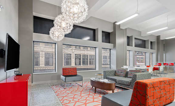 A modern living room with a red cabinet and a grey sofa.