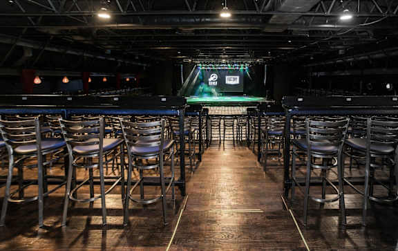 A dark room with a stage and chairs.