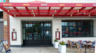 A restaurant with a red awning and a sign that says Brasserie, Brunch, Pastis, Lunch, Dinner.