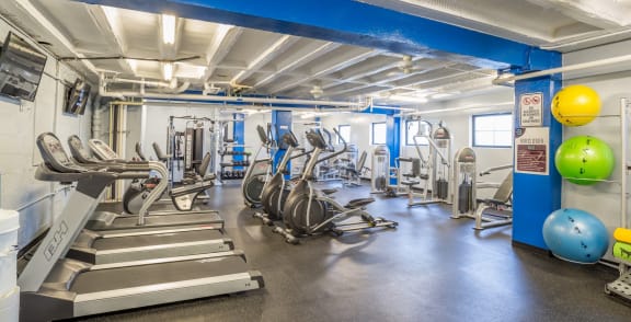 a gym with cardio equipment and weights in a building