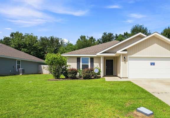 A house with a garage and a driveway in front.