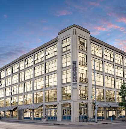 a large building on a city street at sunset