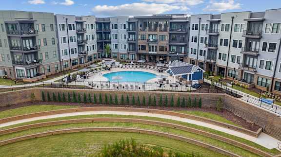 A large swimming pool is surrounded by apartment buildings.