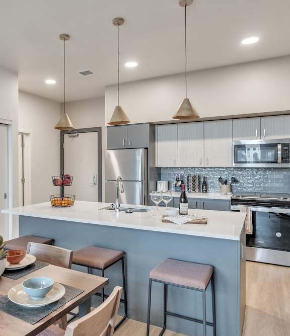 A modern kitchen with a dining table set for two.