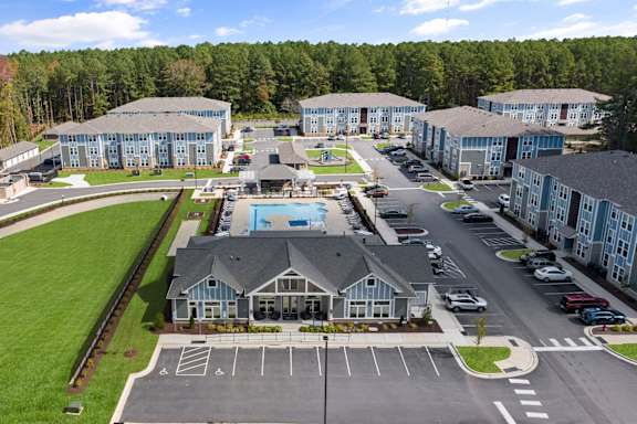 A large building complex with a pool and parking lot.