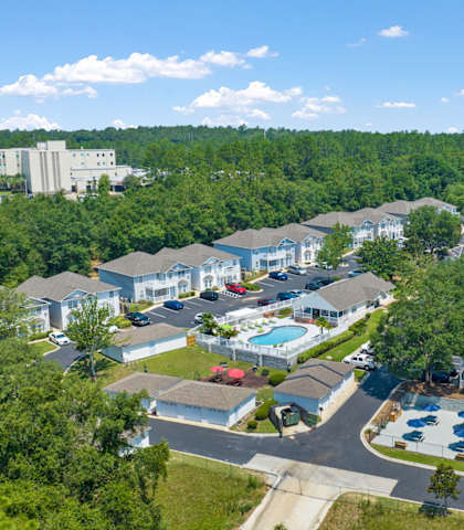 a aerial view of a neighborhood of houses with a pool and trees