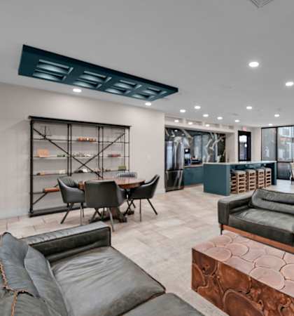 A modern living room with a black leather couch and a wooden coffee table.