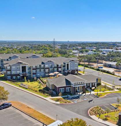 an aerial view of houses on a street with a city in the background