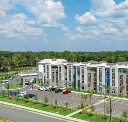 A large multi-story building with a parking lot in front.