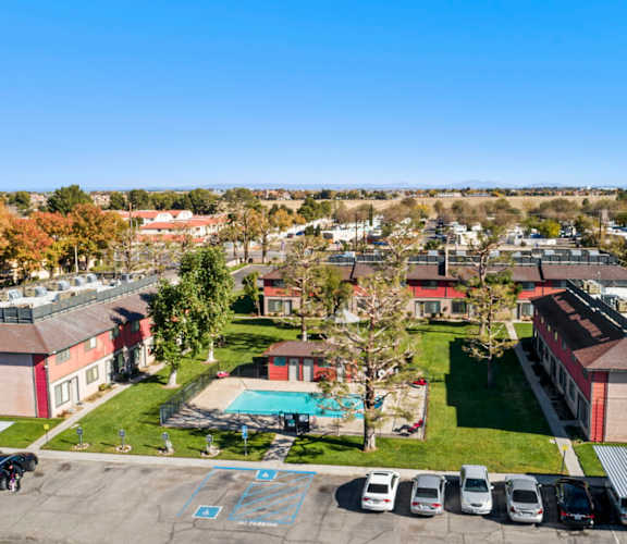 A parking lot with cars and a pool in the middle of a residential area.