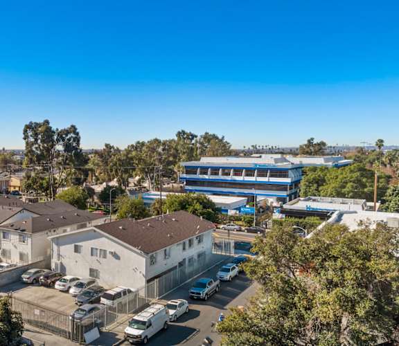 A clear blue sky over a residential area with houses and parked cars.