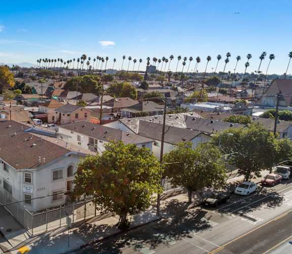 A street view of a residential area with houses and parked cars.
