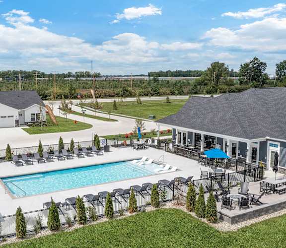 an aerial view of a pool and a house with a patio and a swimming pool