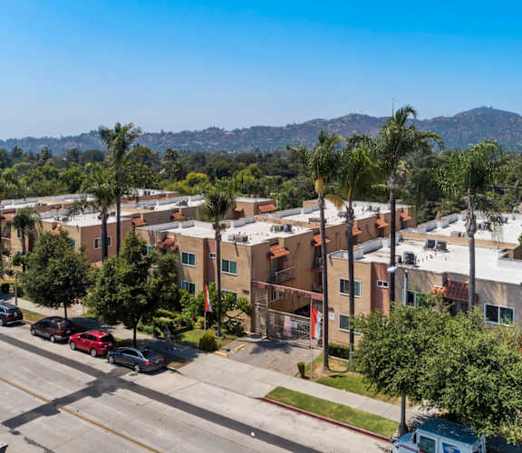 A street view of a residential area with cars parked on the side of the road.