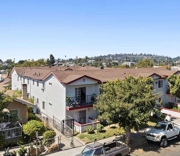 A sunny day in a residential area with houses and parked cars.