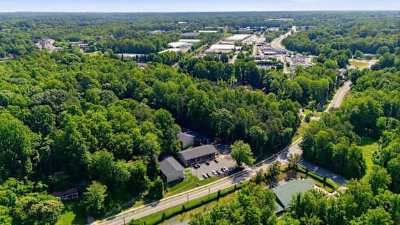 A bird's eye view of a lush green forest with a road running through it.