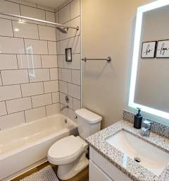 A white bathroom with a toilet, sink, and bathtub.