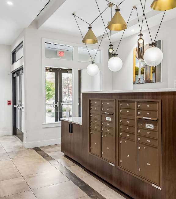 A reception area with a brown counter and hanging lights.