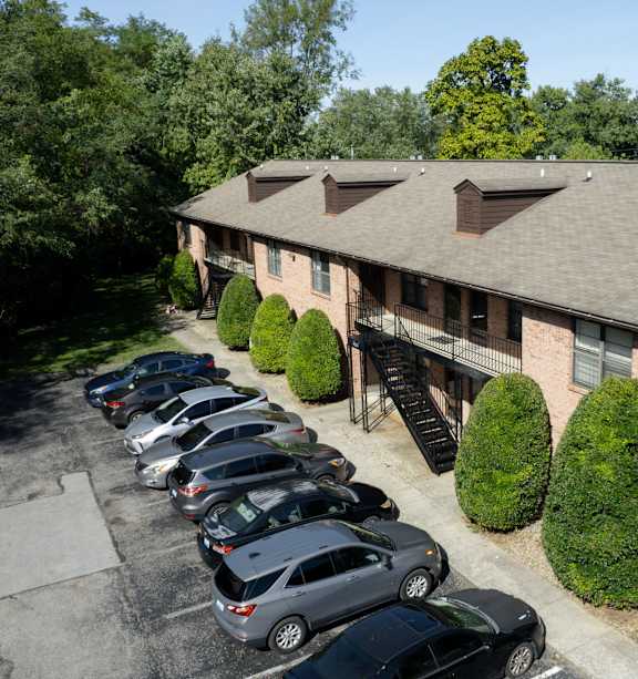 an aerial view of a brick building with cars parked outside