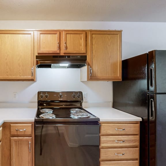 a kitchen with wooden cabinets and a stove and a sink