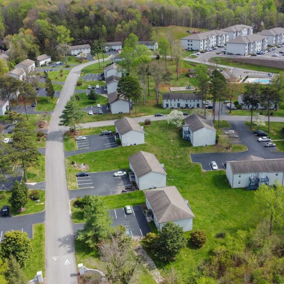 an aerial view of a neighborhood with a road and a body of water