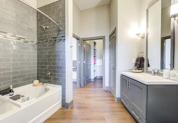 A bathroom with a white sink and a grey tiled wall.