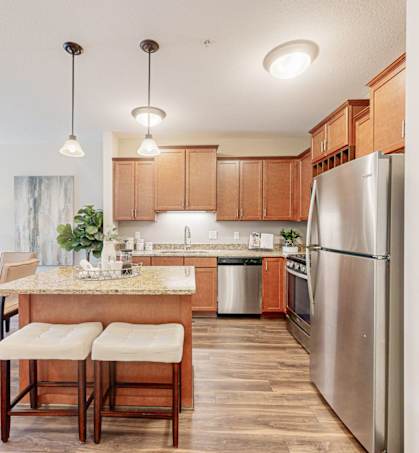 a kitchen and dining room with stainless steel appliances and wooden cabinets
