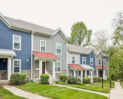 A row of houses with the first one having a blue and white facade.